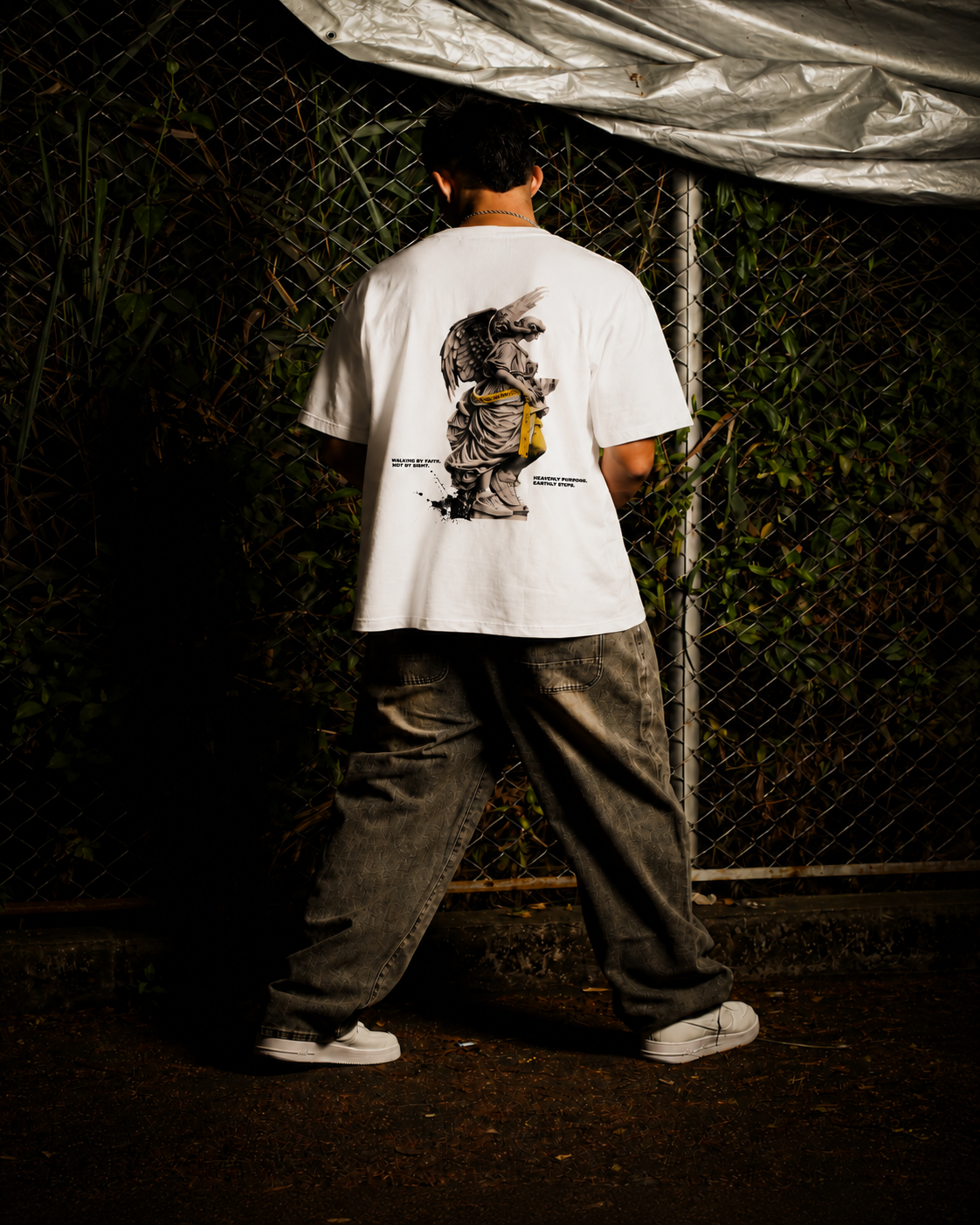 Modelo usando camiseta oversized branca KAIRO GUIDED em ensaio streetwear.
